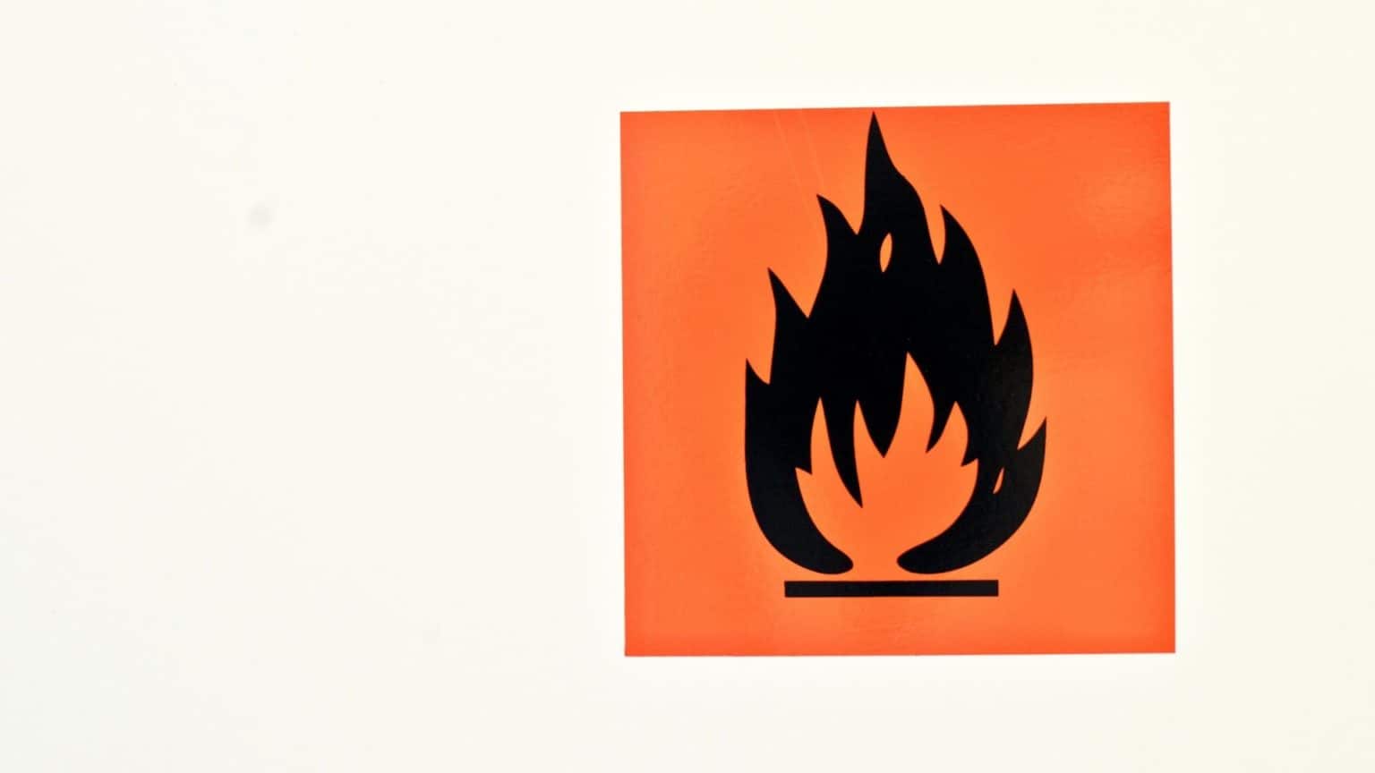 Flammable hazard symbol displayed on a cabinet indicating the storage of fire-risk chemicals or materials.