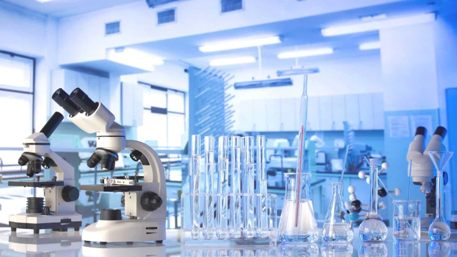 Laboratory with microscopes, vials, and glass instruments arranged on workbenches.