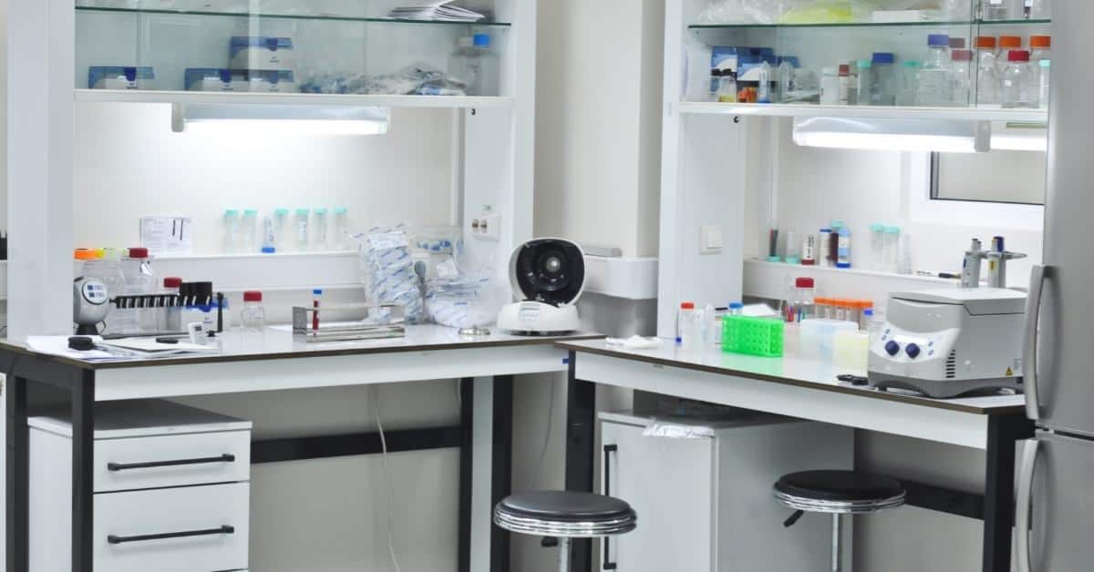 Laboratory workspaces with benches, storage cabinets, and scientific equipment.