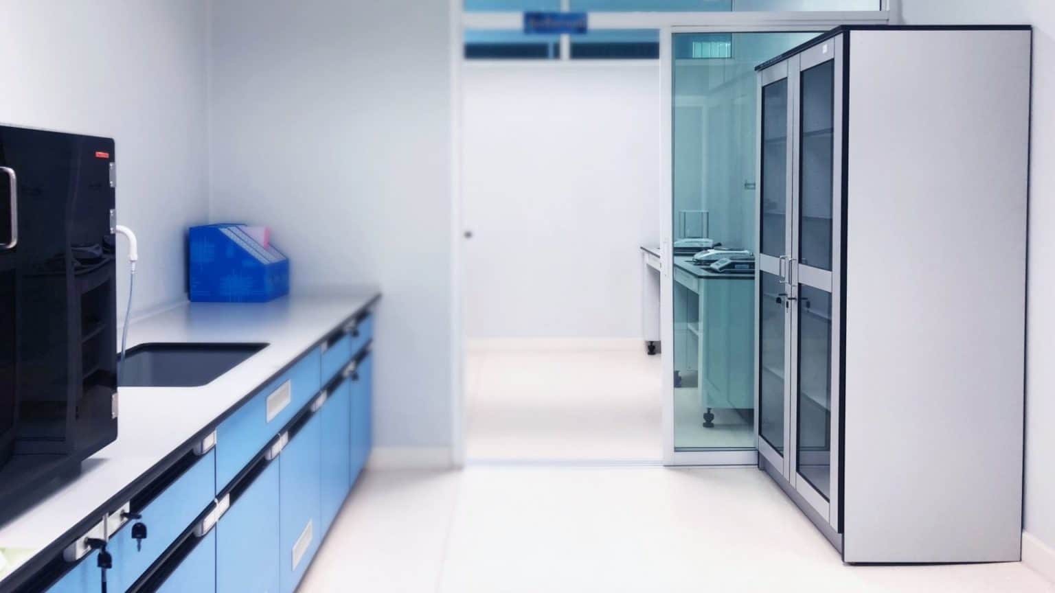 Laboratory interior with work surfaces and storage cabinets.